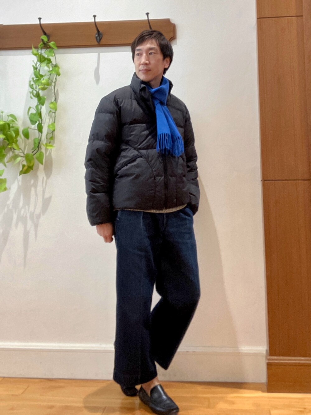 グリーン系のダウンジャケット/コート、ブルー系のニット/セーター、ブルー系のマフラーを着用したメンズの秋コーディネートの7枚目の写真