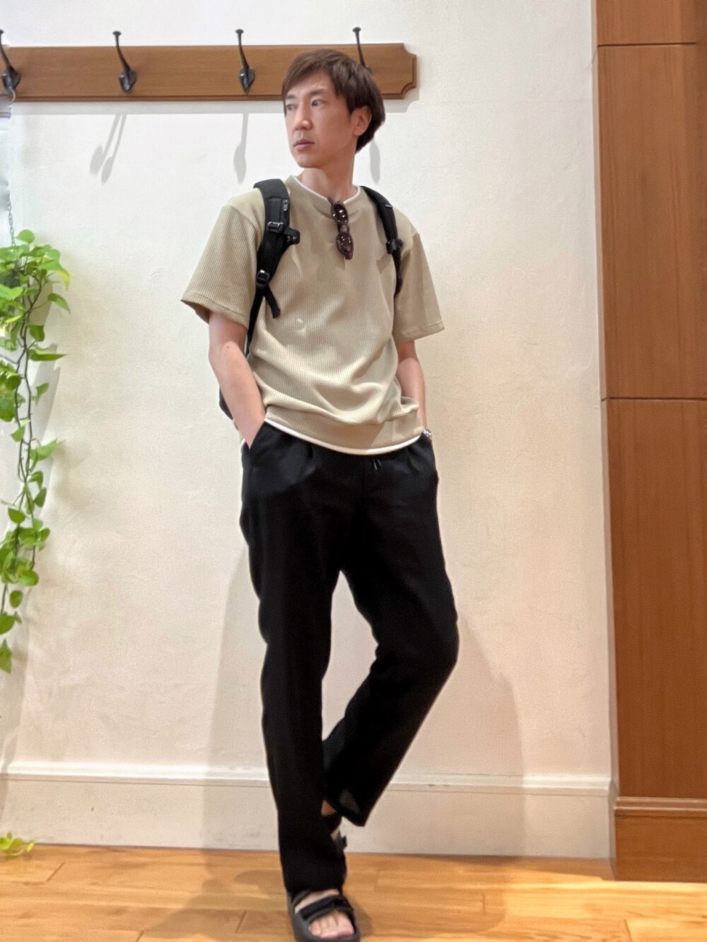 ブラック系のバックパック/リュック、ベージュ系のTシャツ/カットソー、ブラック系のサンダルを着用したメンズの夏コーディネートの6枚目の写真
