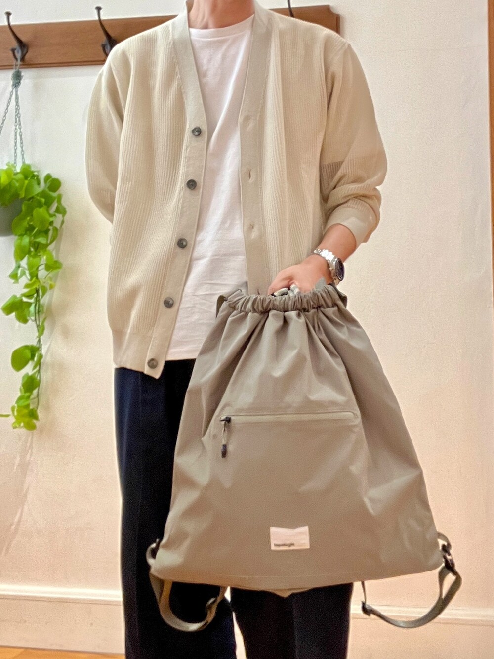 ベージュ系のカーディガン/ボレロ、グリーン系のトートバッグ、ホワイト系のTシャツ/カットソーを着用したメンズの春コーディネートの7枚目の写真