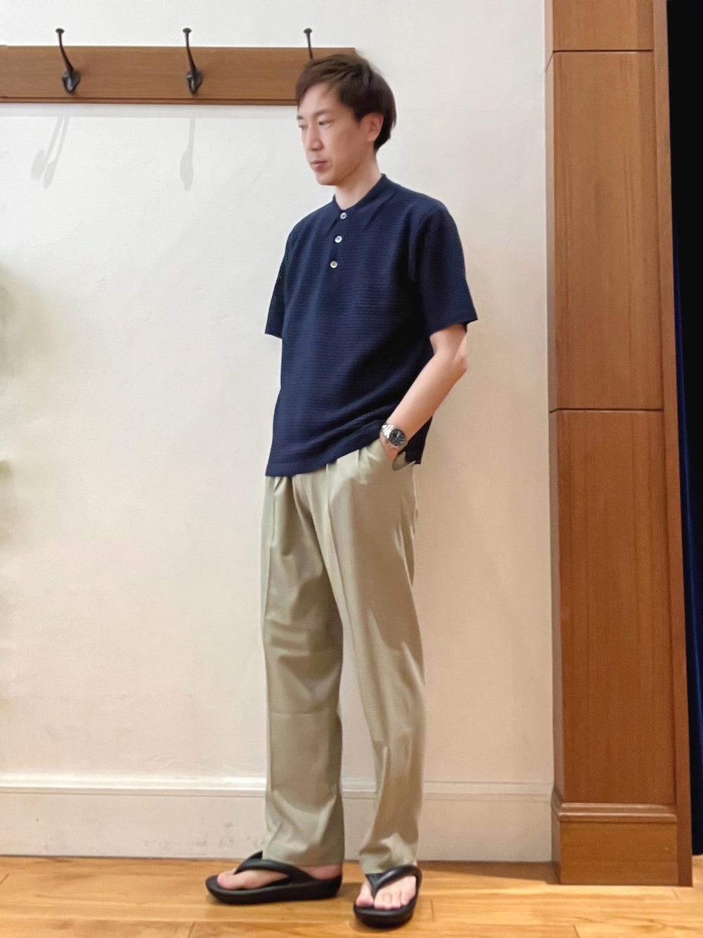 ブルー系のポロシャツ、ベージュ系のその他パンツ、ブラック系のバックパック/リュックを着用したメンズの春コーディネートの3枚目の写真