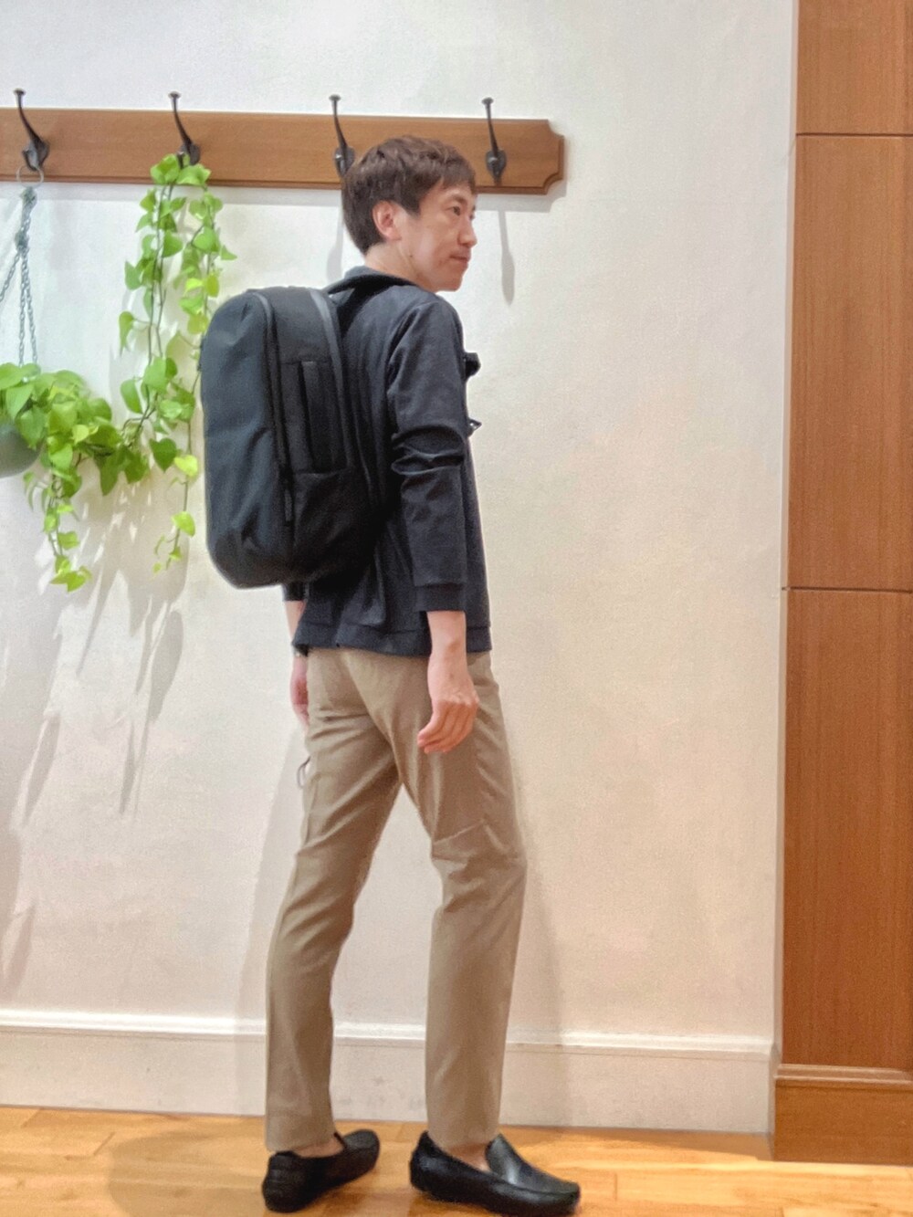 ブルー系のカーディガン/ボレロ、ホワイト系のTシャツ/カットソー、ブラック系のバックパック/リュックを着用したメンズの秋コーディネートの6枚目の写真