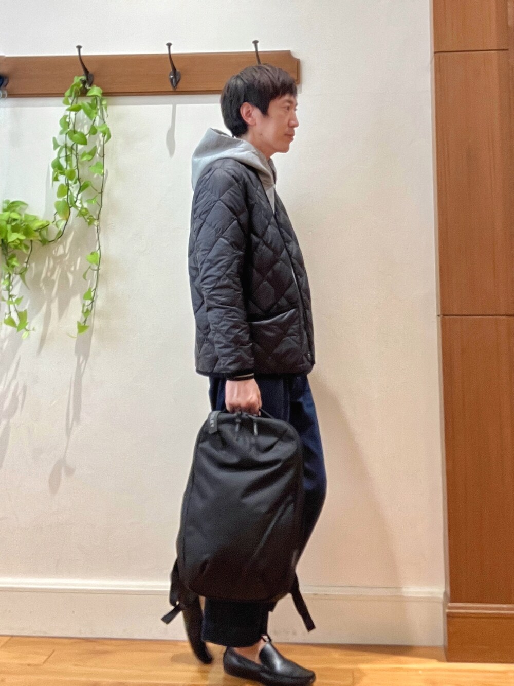 ブラック系のダウンジャケット/コート、グレー系のパーカー、ブラック系のバックパック/リュックを着用したメンズの秋コーディネートの7枚目の写真