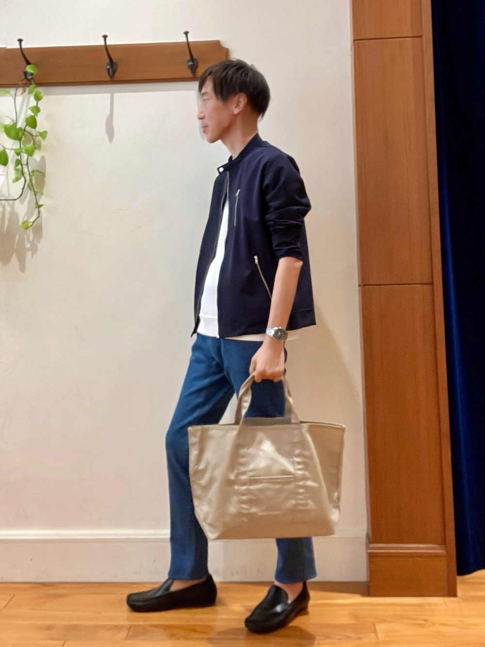 ブルー系のデニムパンツ、ベージュ系のトートバッグ、ホワイト系のTシャツ/カットソーを着用したメンズの秋コーディネートの4枚目の写真