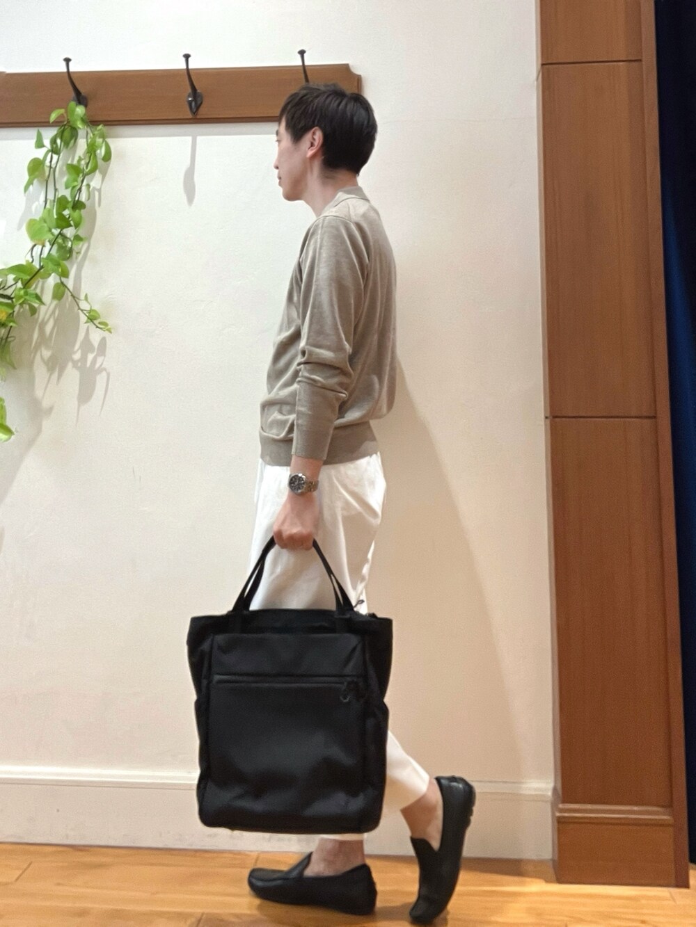ホワイト系のデニムパンツ、ブラック系のトートバッグ、ベージュ系のニット/セーターを着用したメンズの冬コーディネートの4枚目の写真