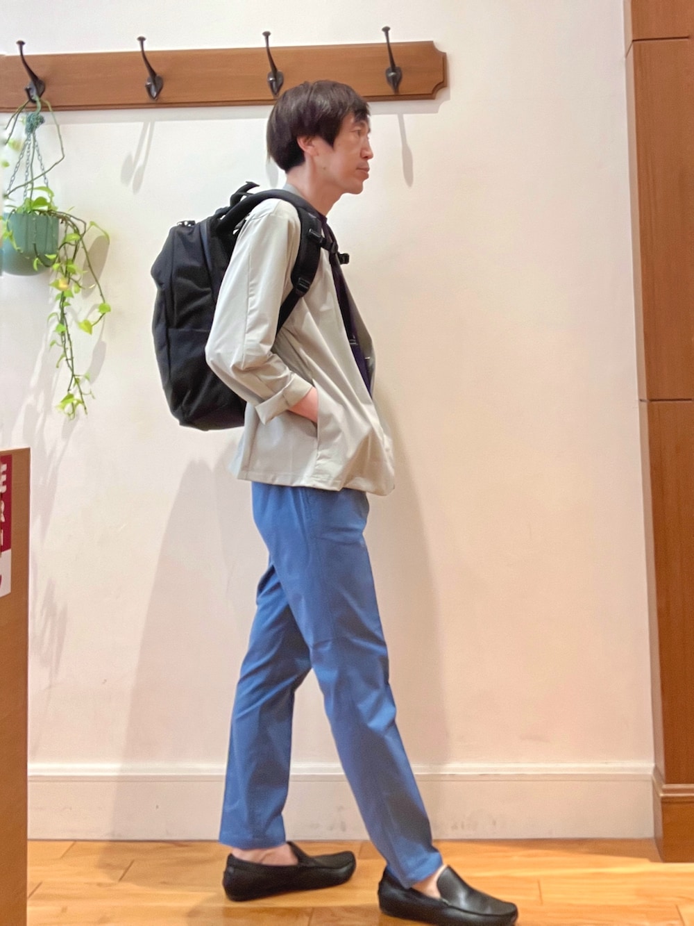 ブラック系のバックパック/リュック、ブルー系のチノパンツ、ブルー系のTシャツ/カットソーを着用したメンズの春コーディネートの6枚目の写真