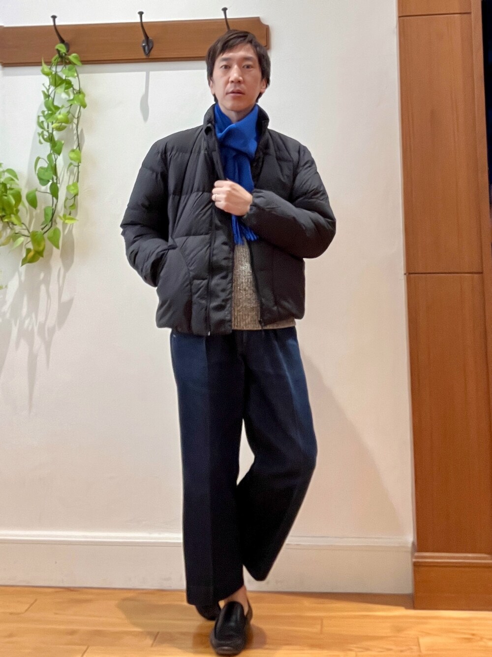 グリーン系のダウンジャケット/コート、ブルー系のニット/セーター、ブルー系のマフラーを着用したメンズの秋コーディネートの2枚目の写真