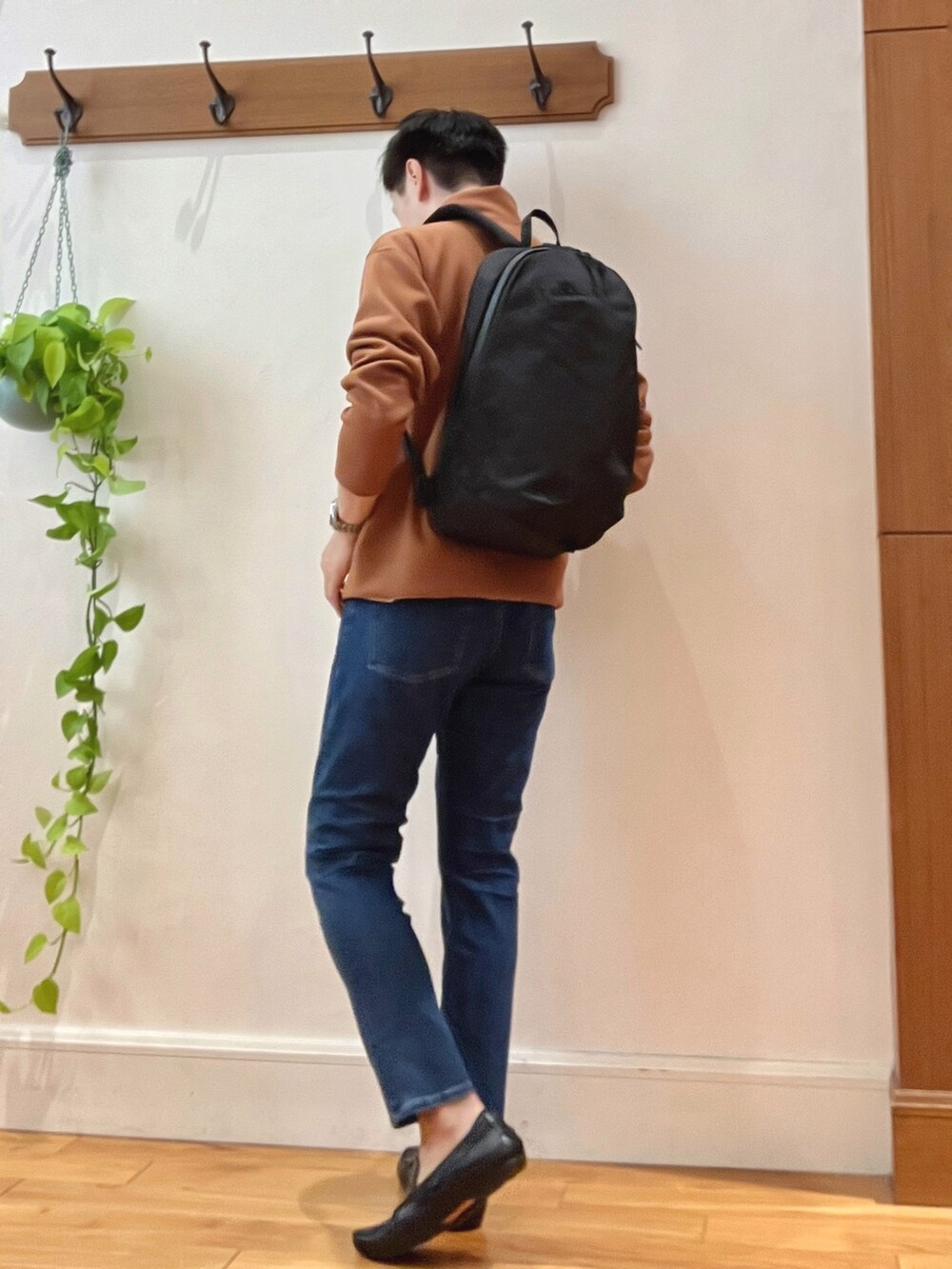 レッド系のカーディガン/ボレロ、ホワイト系のTシャツ/カットソー、ブラック系のバックパック/リュックを着用したメンズの秋コーディネートの4枚目の写真