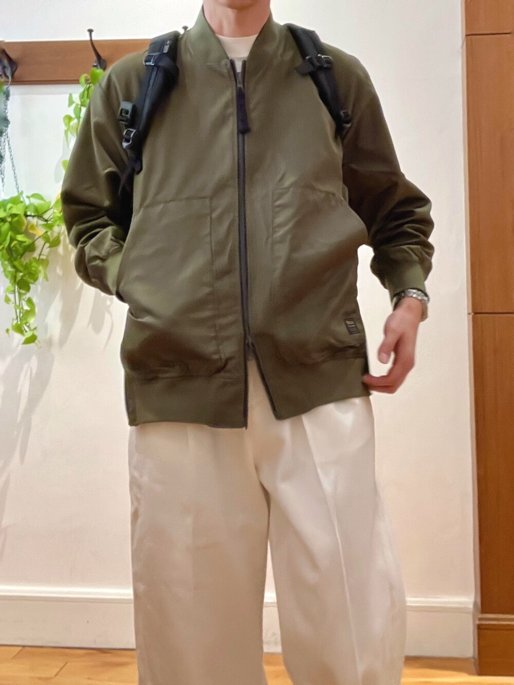 ブラック系のブルゾン、ホワイト系のデニムパンツ、ブラック系のバックパック/リュックを着用したメンズの冬コーディネートの4枚目の写真