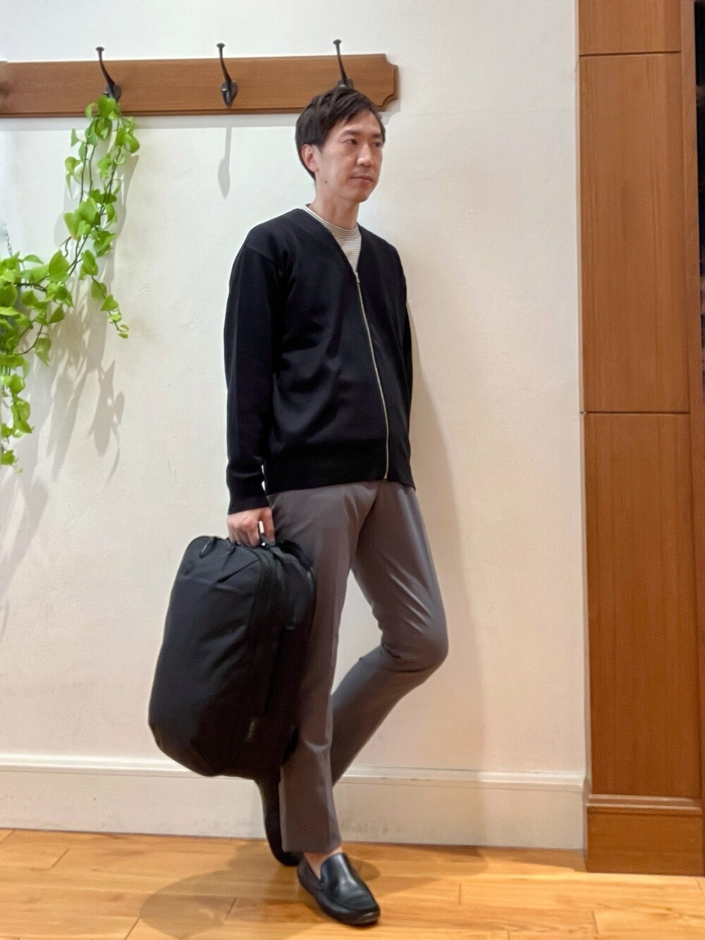 ブラック系のカーディガン/ボレロ、ホワイト系のTシャツ/カットソー、ブラック系のバックパック/リュックを着用したメンズの冬コーディネートの6枚目の写真