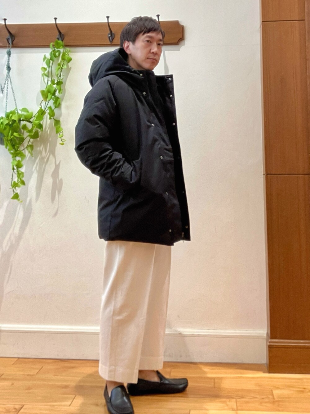 ホワイト系のTシャツ/カットソー、ブラック系のダウンジャケット/コート、ブルー系のカーディガン/ボレロを着用したメンズの冬コーディネートの5枚目の写真