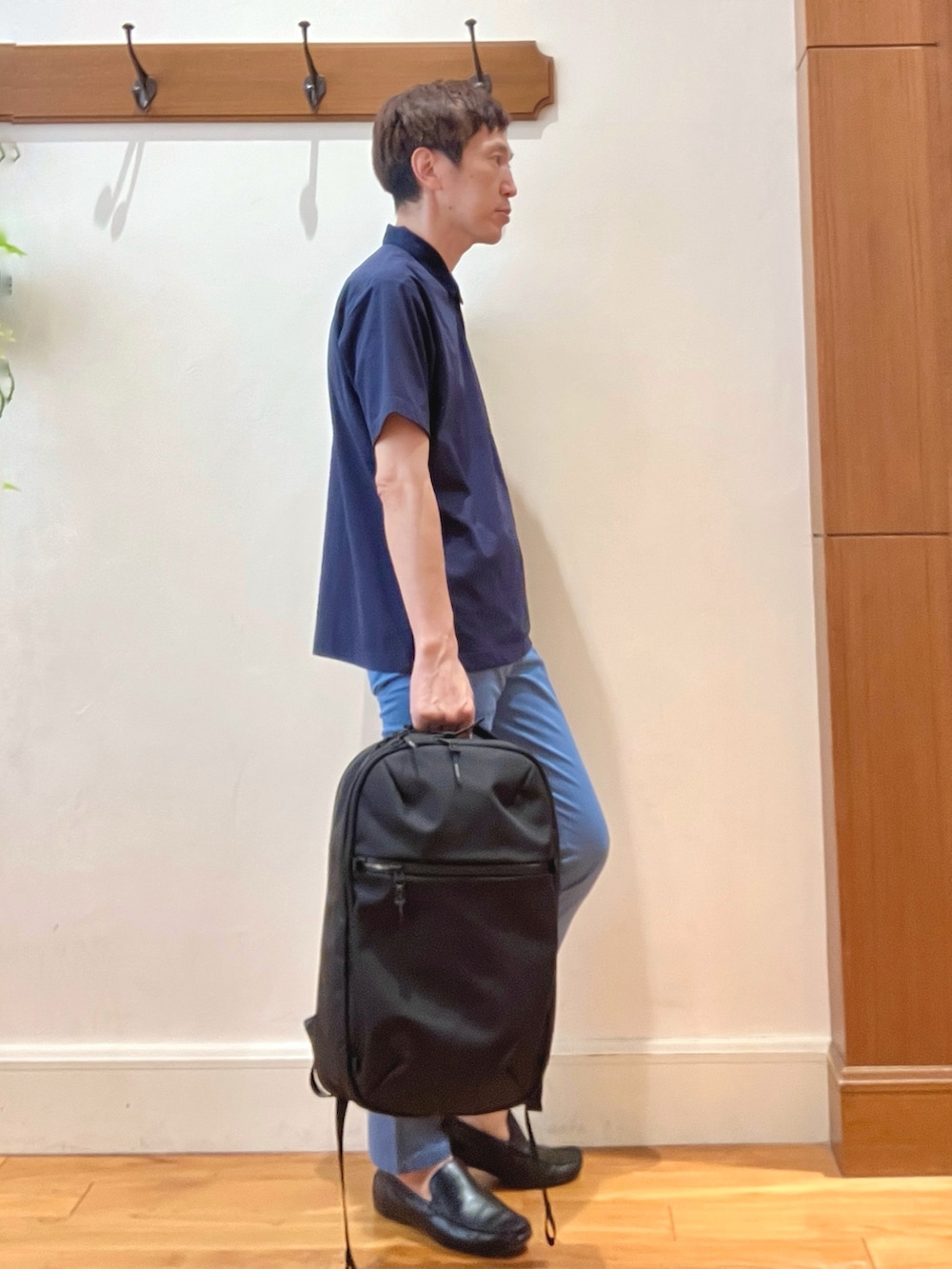 ブルー系のチノパンツ、ブラック系のバックパック/リュック、ブルー系のポロシャツを着用したメンズの夏コーディネートの7枚目の写真