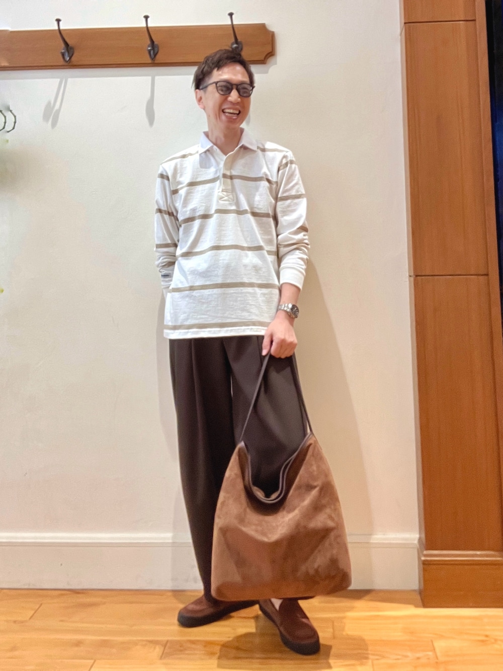 イエロー系のショルダーバッグ、ブラウン系のスニーカー、ホワイト系のTシャツ/カットソーを着用したメンズの秋コーディネートの2枚目の写真