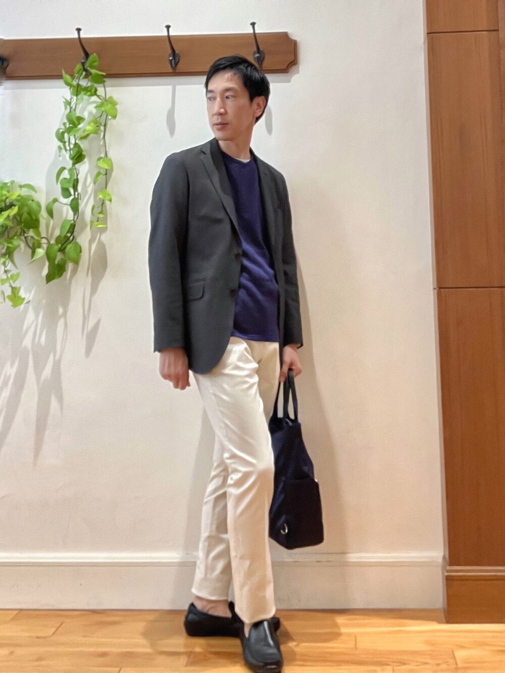 パープル系のニット/セーター、ホワイト系のチノパンツ、ブルー系のトートバッグを着用したメンズの秋コーディネートの5枚目の写真