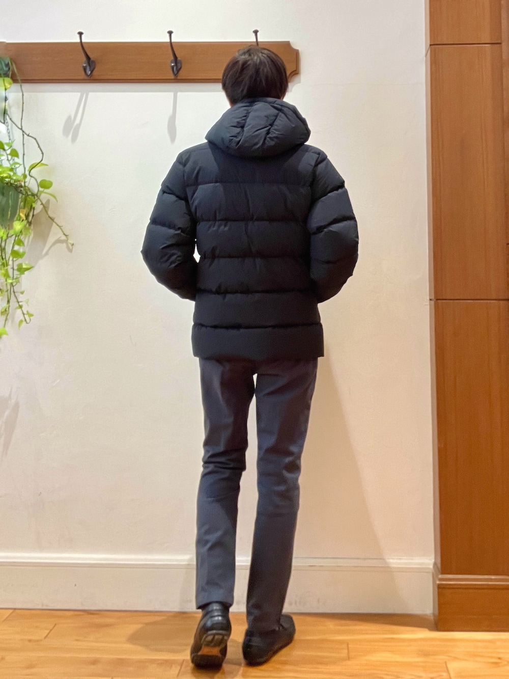 グレー系のチノパンツ、ブラック系のニット/セーター、ブラック系のダウンジャケット/コートを着用したメンズの冬コーディネートの4枚目の写真