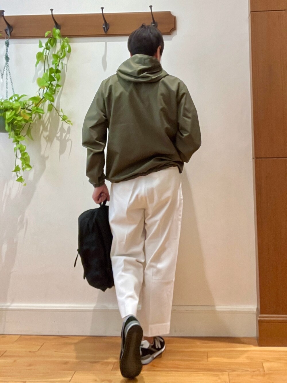 ホワイト系のデニムパンツ、ブラック系のバックパック/リュック、グリーン系のブルゾンを着用したメンズの冬コーディネートの3枚目の写真