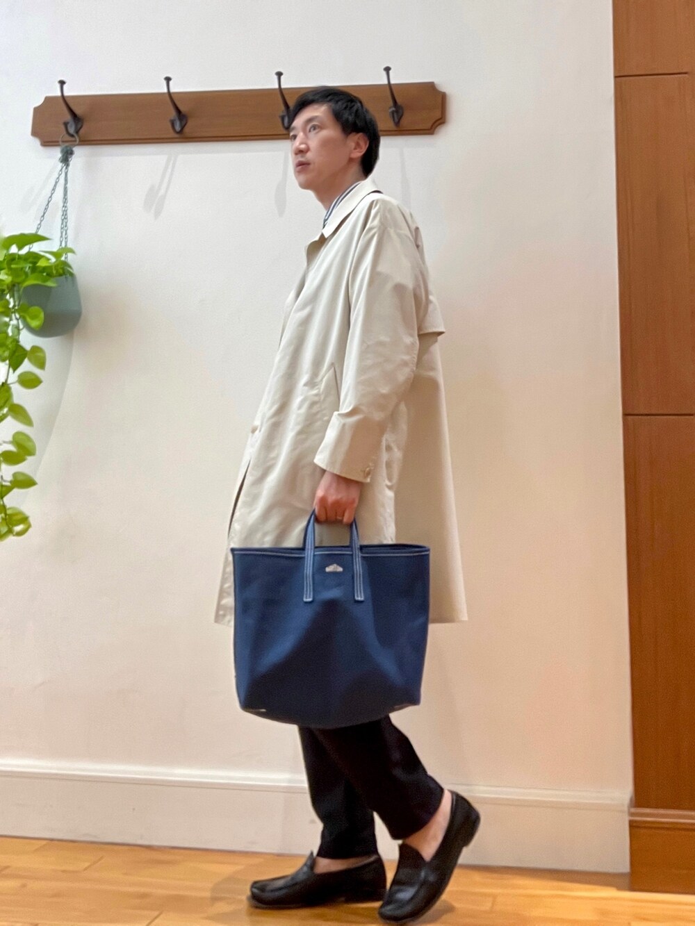 ホワイト系のステンカラーコート、グレー系のシャツ/ブラウス、レッド系のトートバッグを着用したメンズの春コーディネートの5枚目の写真