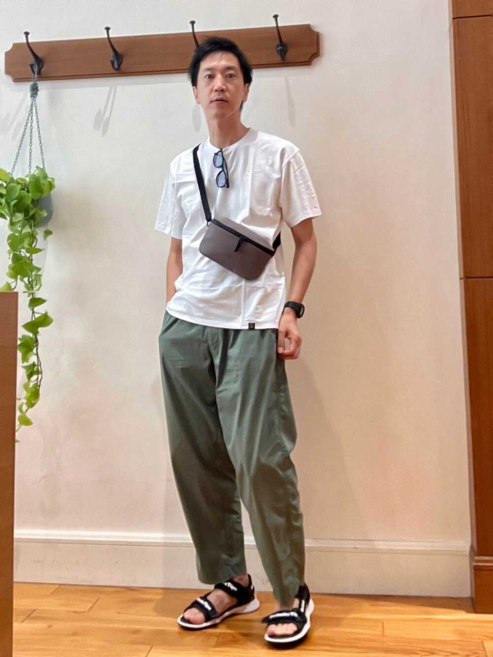 パープル系のショルダーバッグ、ホワイト系のTシャツ/カットソー、ブラック系のサングラスを着用したメンズの夏コーディネートの3枚目の写真