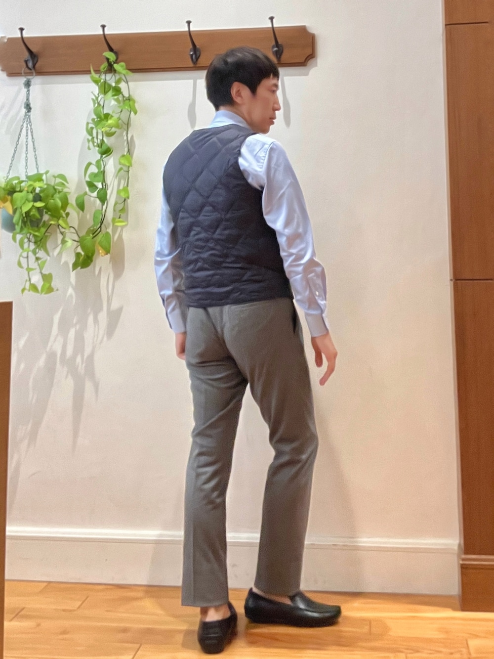 グレー系のその他パンツ、ブルー系のビジネスシャツ、ブルー系のダウンベストを着用したメンズの秋コーディネートの7枚目の写真