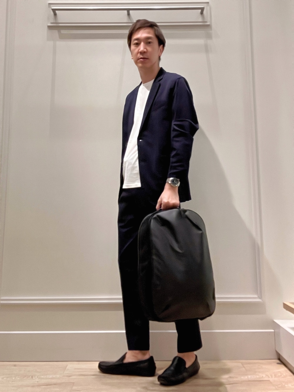 ブルー系のテーラードジャケット、ブラック系のバックパック/リュック、ブルー系のその他パンツを着用したメンズの冬コーディネートの2枚目の写真