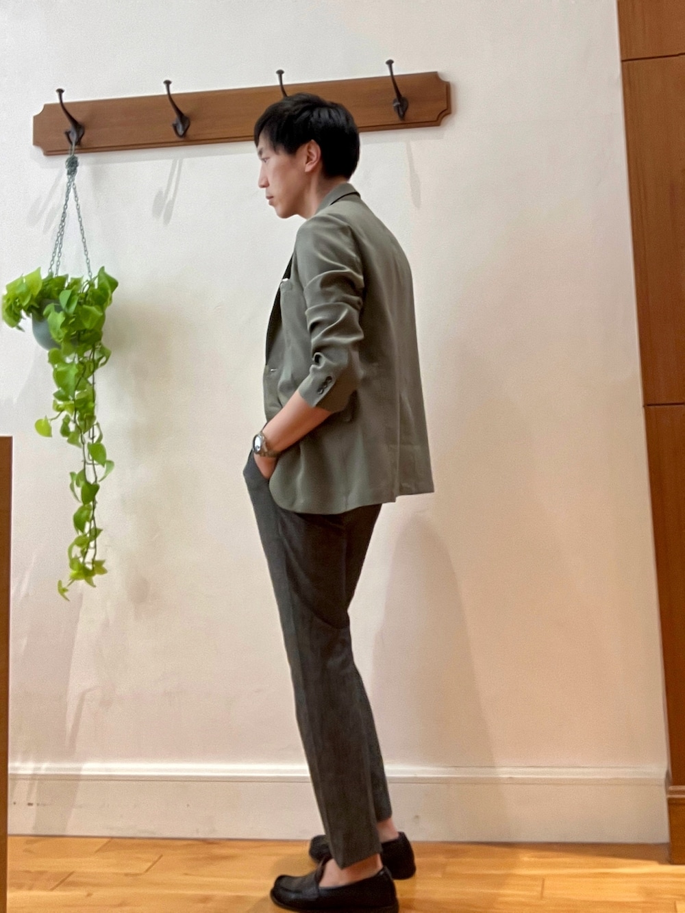 グリーン系のテーラードジャケット、ブラック系のポロシャツ、グレー系のその他パンツを着用したメンズの春コーディネートの4枚目の写真