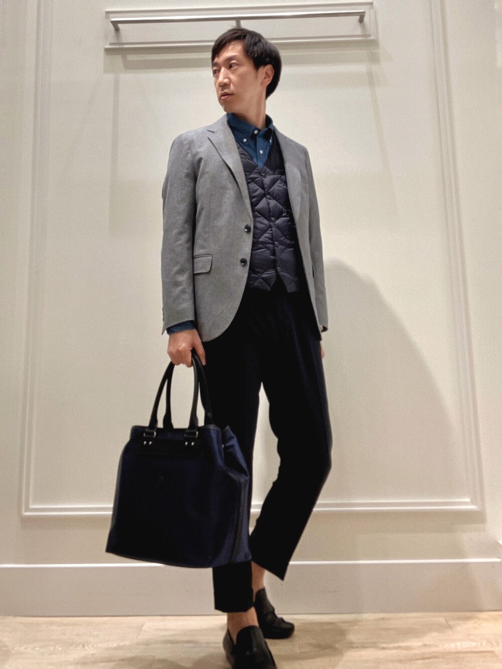 グレー系のテーラードジャケット、ブルー系のシャツ/ブラウス、ブラック系のトートバッグを着用したメンズの秋コーディネートの5枚目の写真