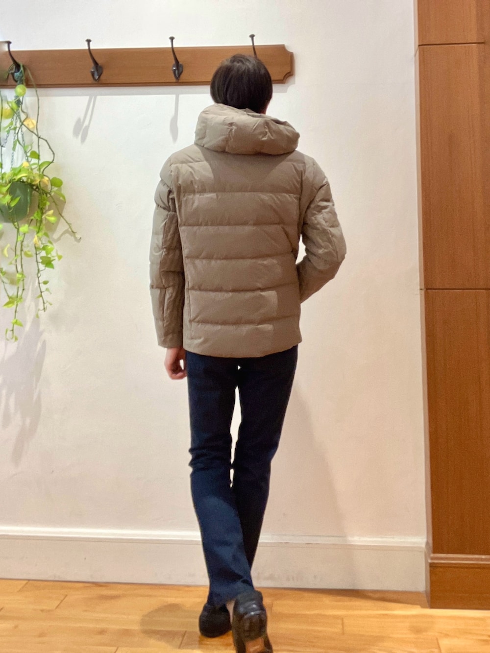 グリーン系のダウンジャケット/コート、ブルー系のニット/セーター、ブルー系のデニムパンツを着用したメンズの冬コーディネートの5枚目の写真