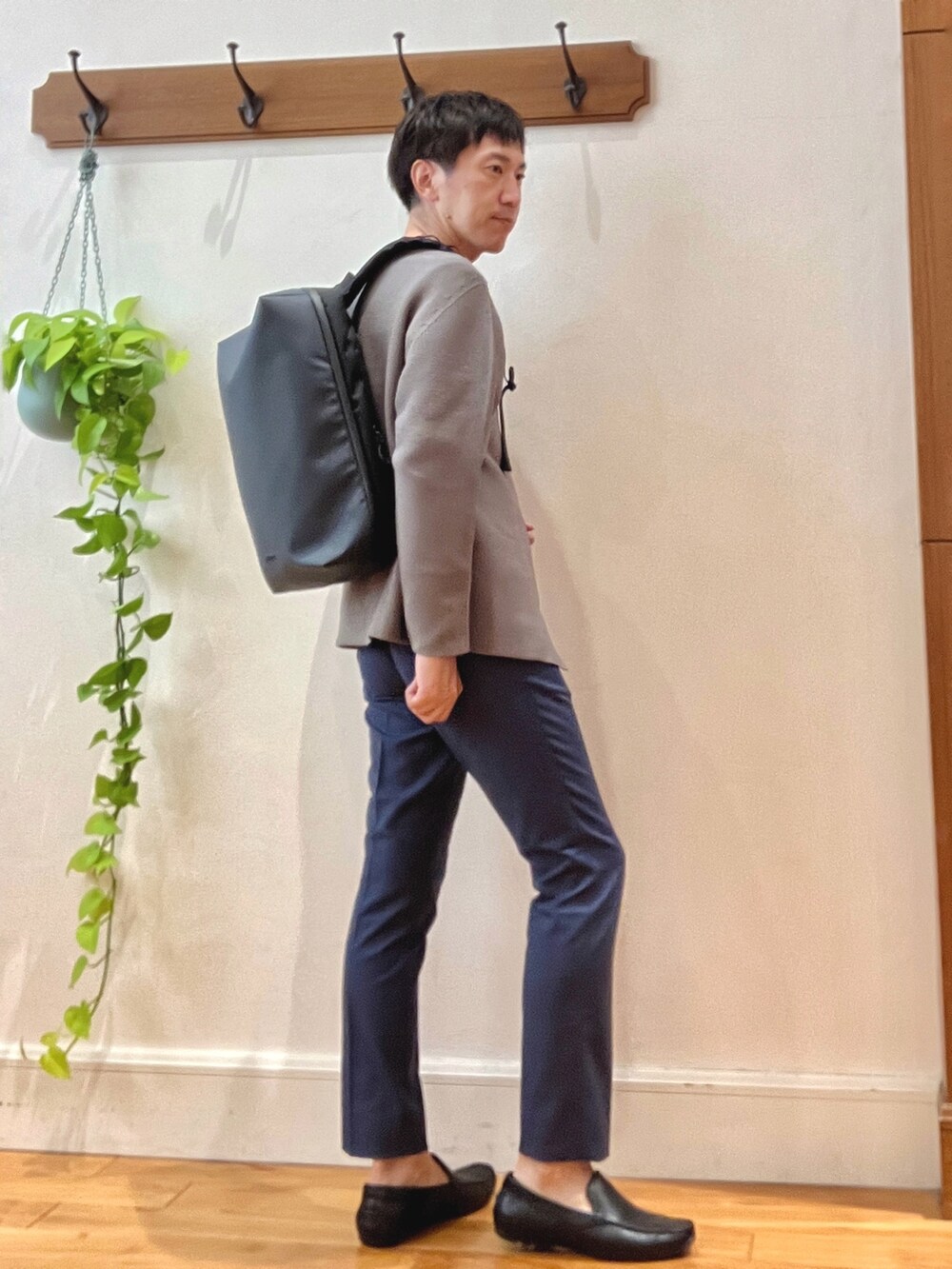 グリーン系のカーディガン/ボレロ、ブラック系のTシャツ/カットソー、ブルー系のバックパック/リュックを着用したメンズの秋コーディネートの7枚目の写真