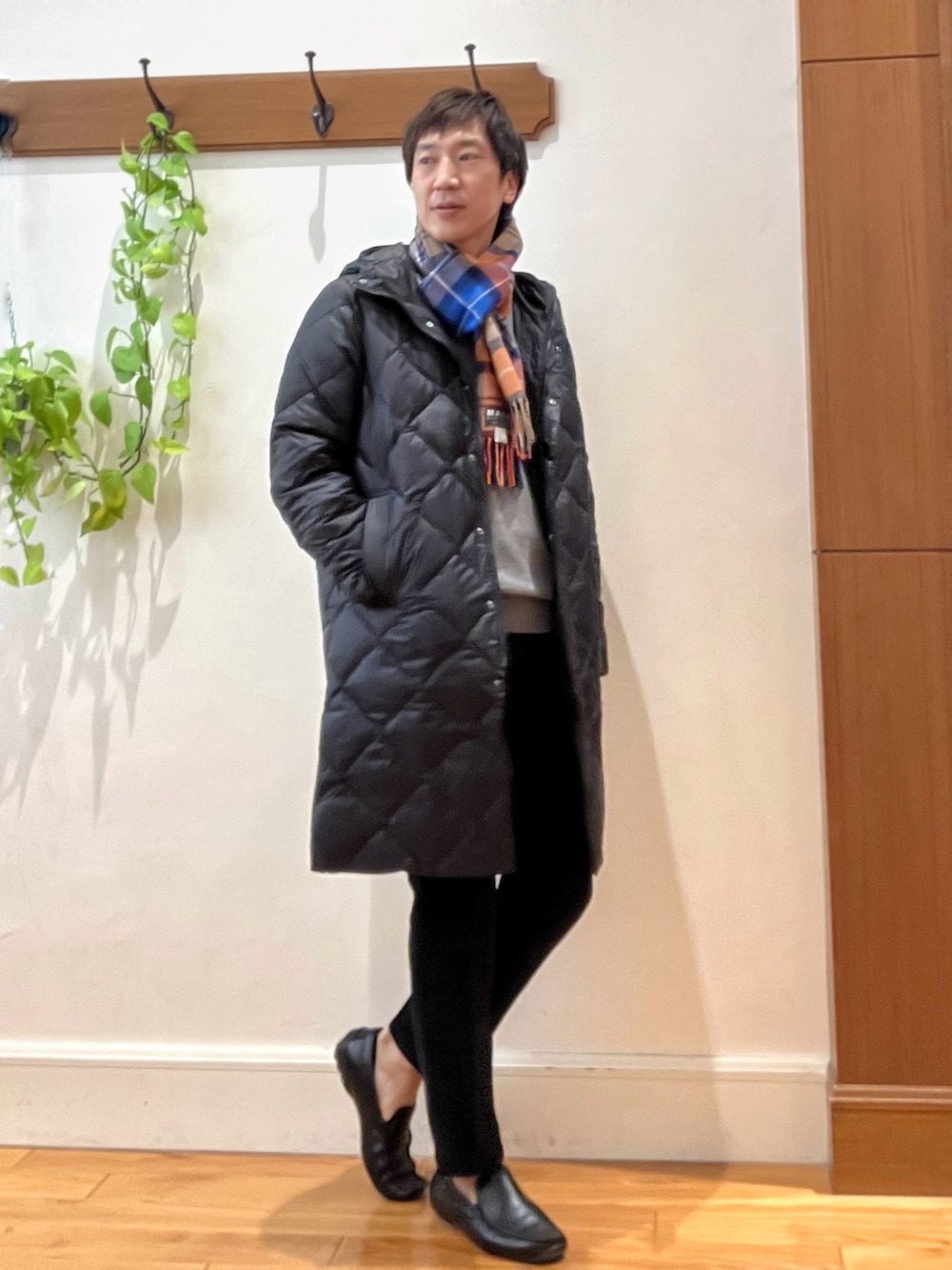 ブラック系のダウンジャケット/コート、グレー系のニット/セーター、ブラック系のその他パンツを着用したメンズの秋コーディネートの6枚目の写真