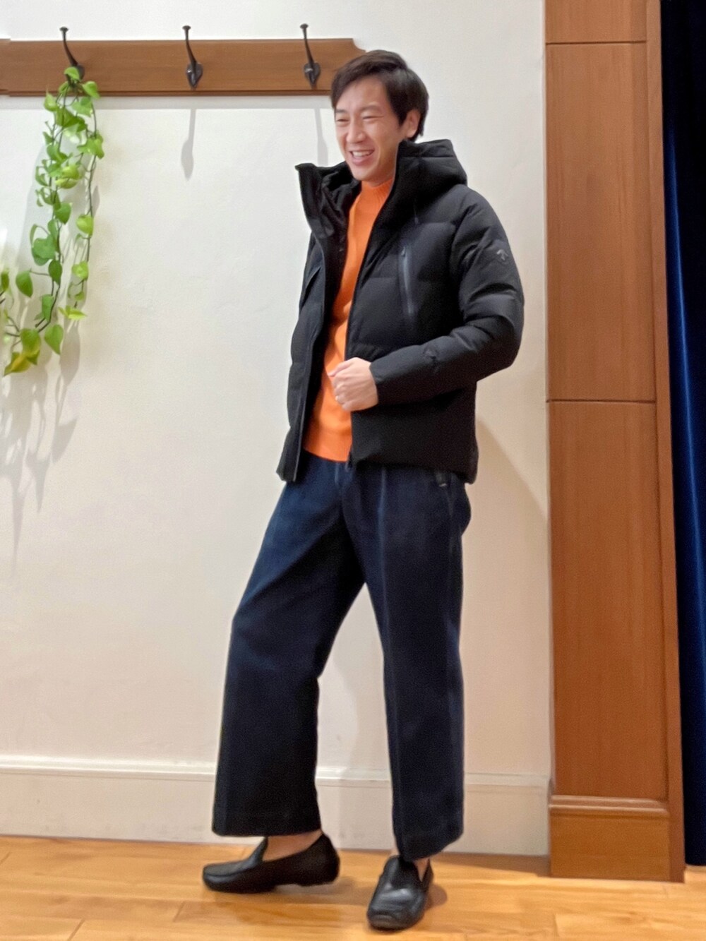 ブラック系のダウンジャケット/コート、オレンジ系のニット/セーターを着用したメンズの秋コーディネートの3枚目の写真