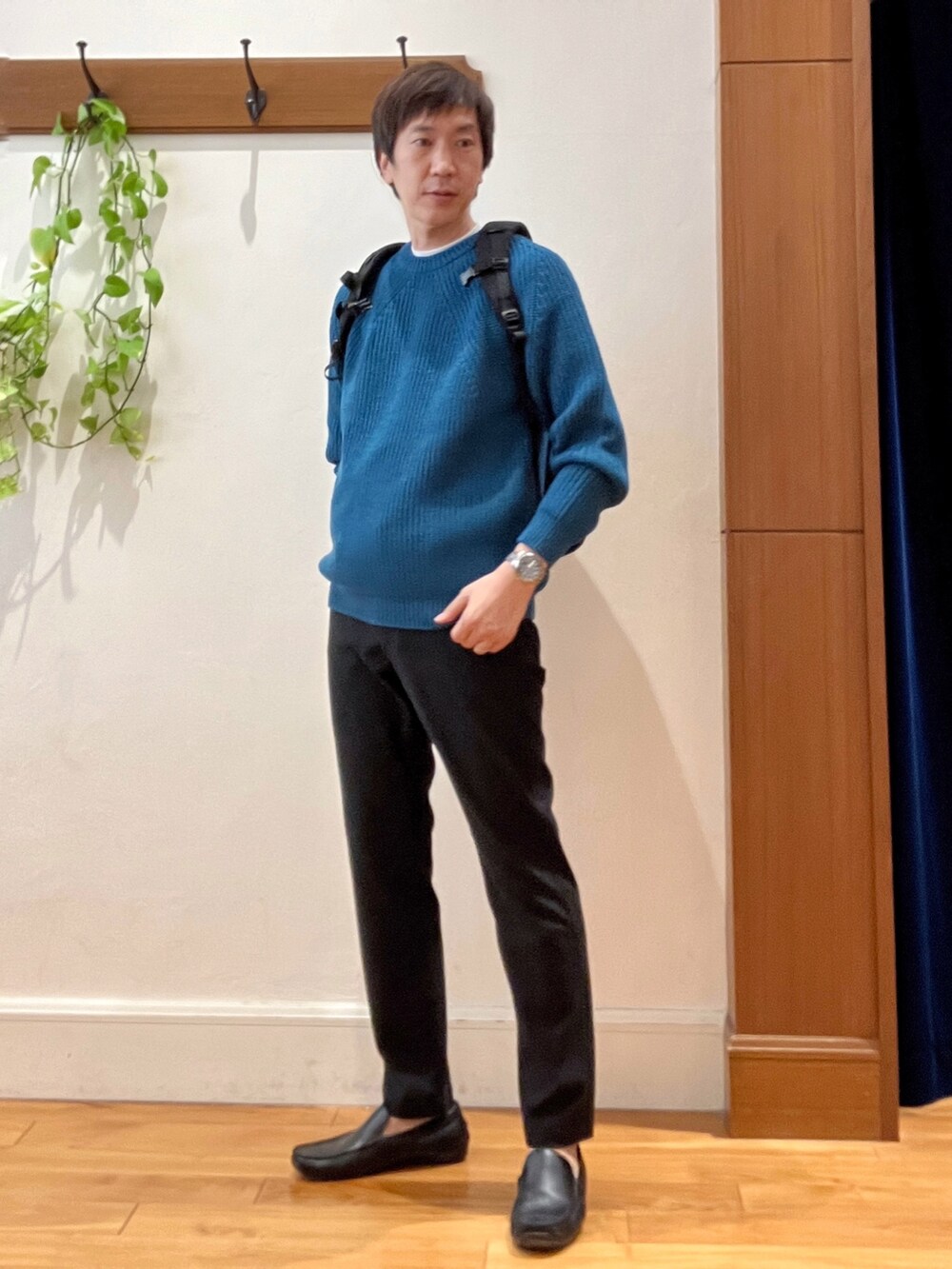 ブルー系のニット/セーター、グレー系のその他パンツ、グレー系のバックパック/リュックを着用したメンズの秋コーディネートの2枚目の写真