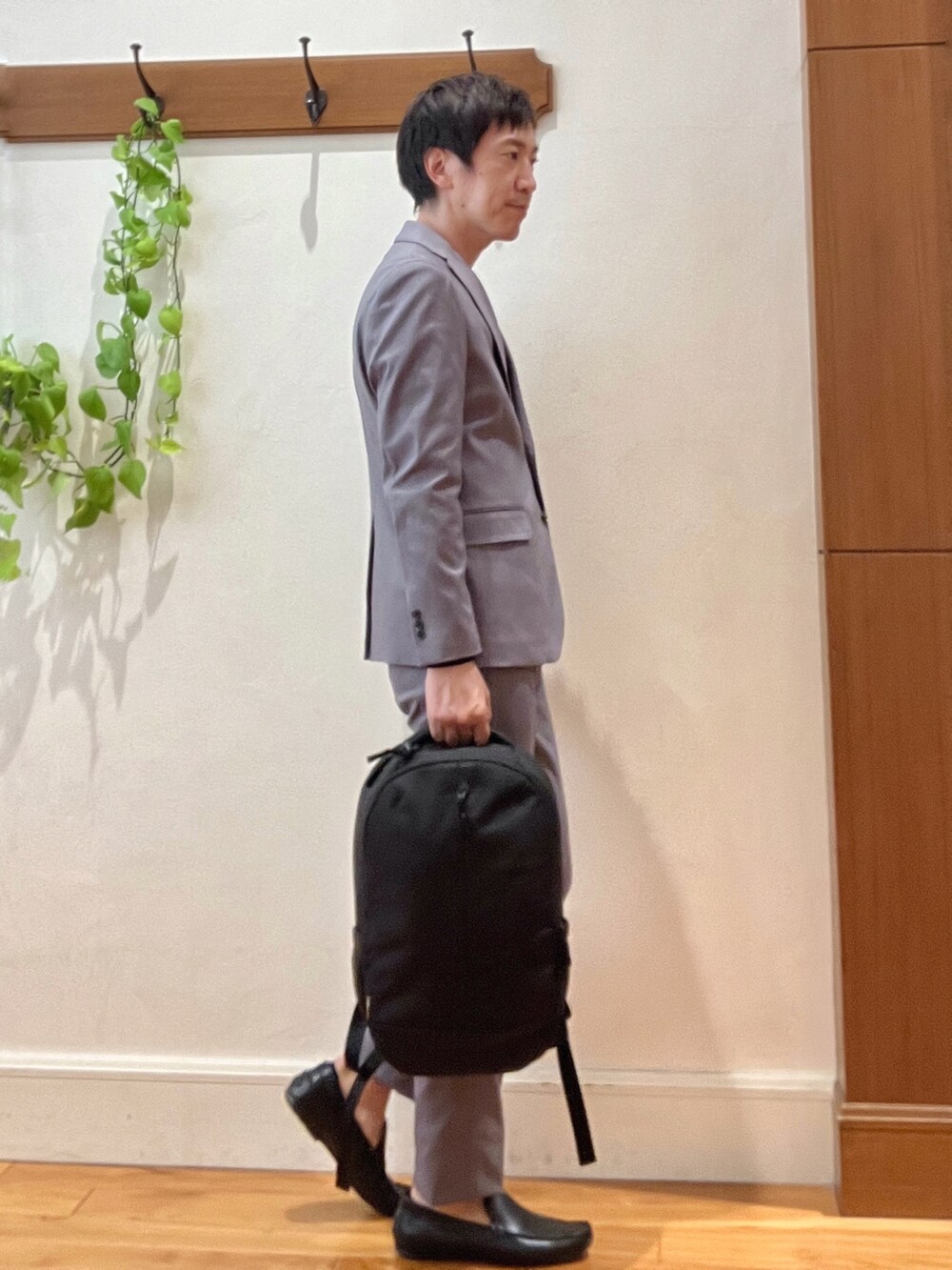 ブラック系のバックパック/リュック、ブラック系のTシャツ/カットソー、グレー系のテーラードジャケットを着用したメンズの秋コーディネートの6枚目の写真