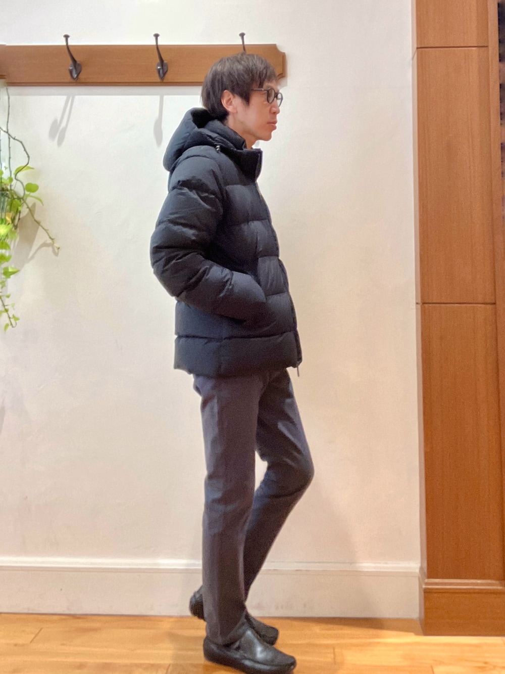 グレー系のチノパンツ、ブラック系のニット/セーター、ブラック系のダウンジャケット/コートを着用したメンズの冬コーディネートの6枚目の写真