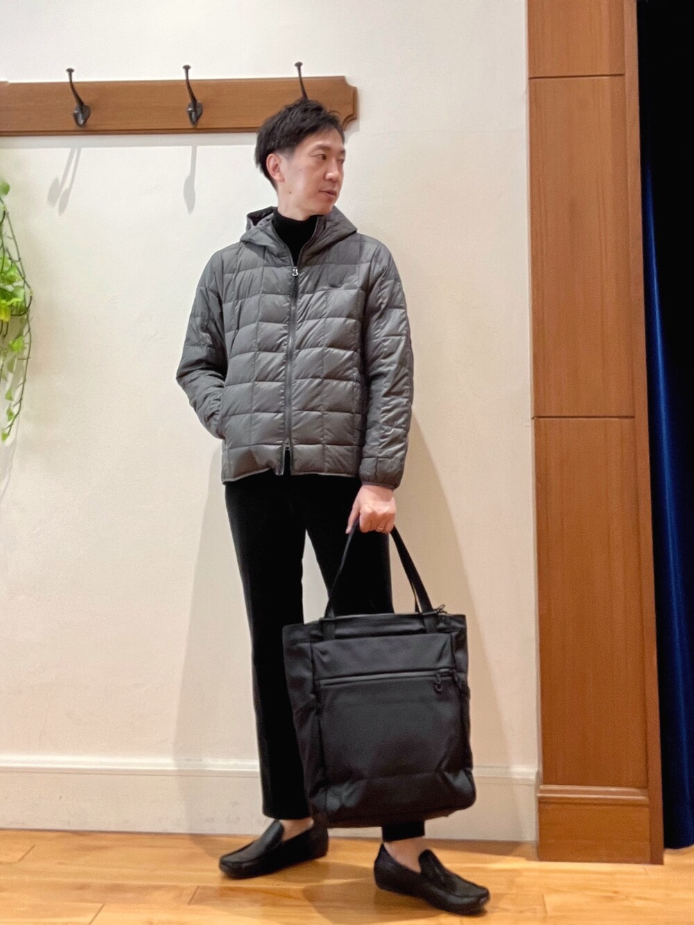 ブラック系のニット/セーター、グレー系のダウンジャケット/コート、ブラック系のその他パンツを着用したメンズの冬コーディネートの2枚目の写真