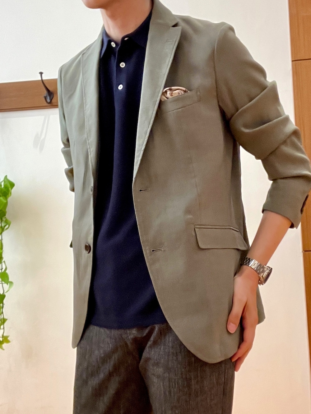 グリーン系のテーラードジャケット、ブラック系のポロシャツ、グレー系のその他パンツを着用したメンズの春コーディネートの7枚目の写真