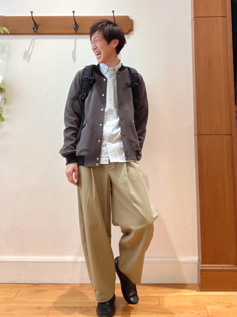 グレー系のブルゾン、グリーン系のシャツ/ブラウス、ブラック系のバックパック/リュックを着用したメンズの冬コーディネートの7枚目の写真