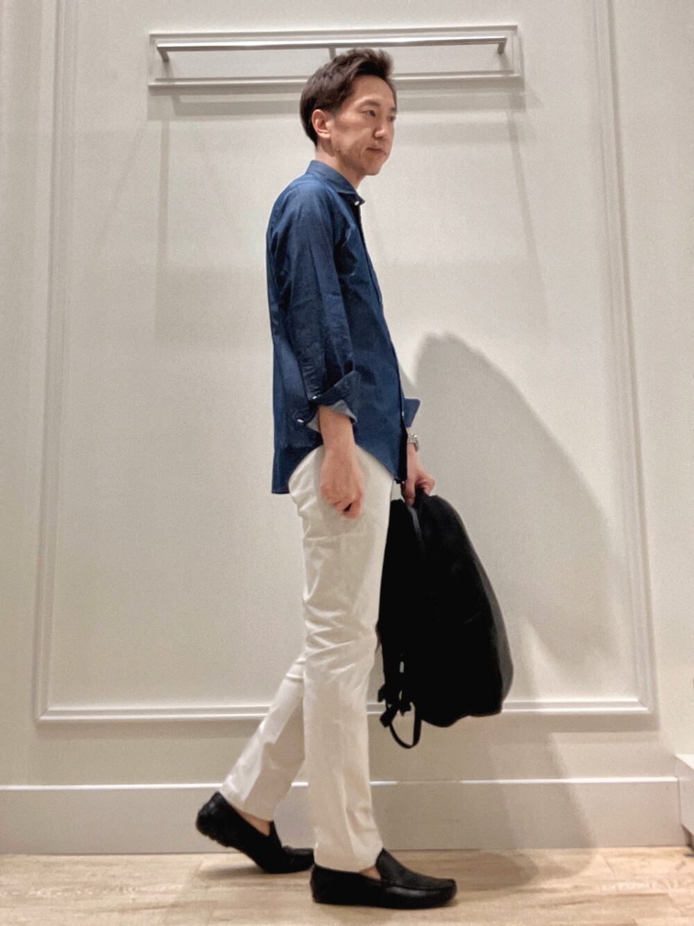 ブラック系のバックパック/リュック、グレー系のチノパンツ、ブルー系のシャツ/ブラウスを着用したメンズの冬コーディネートの6枚目の写真