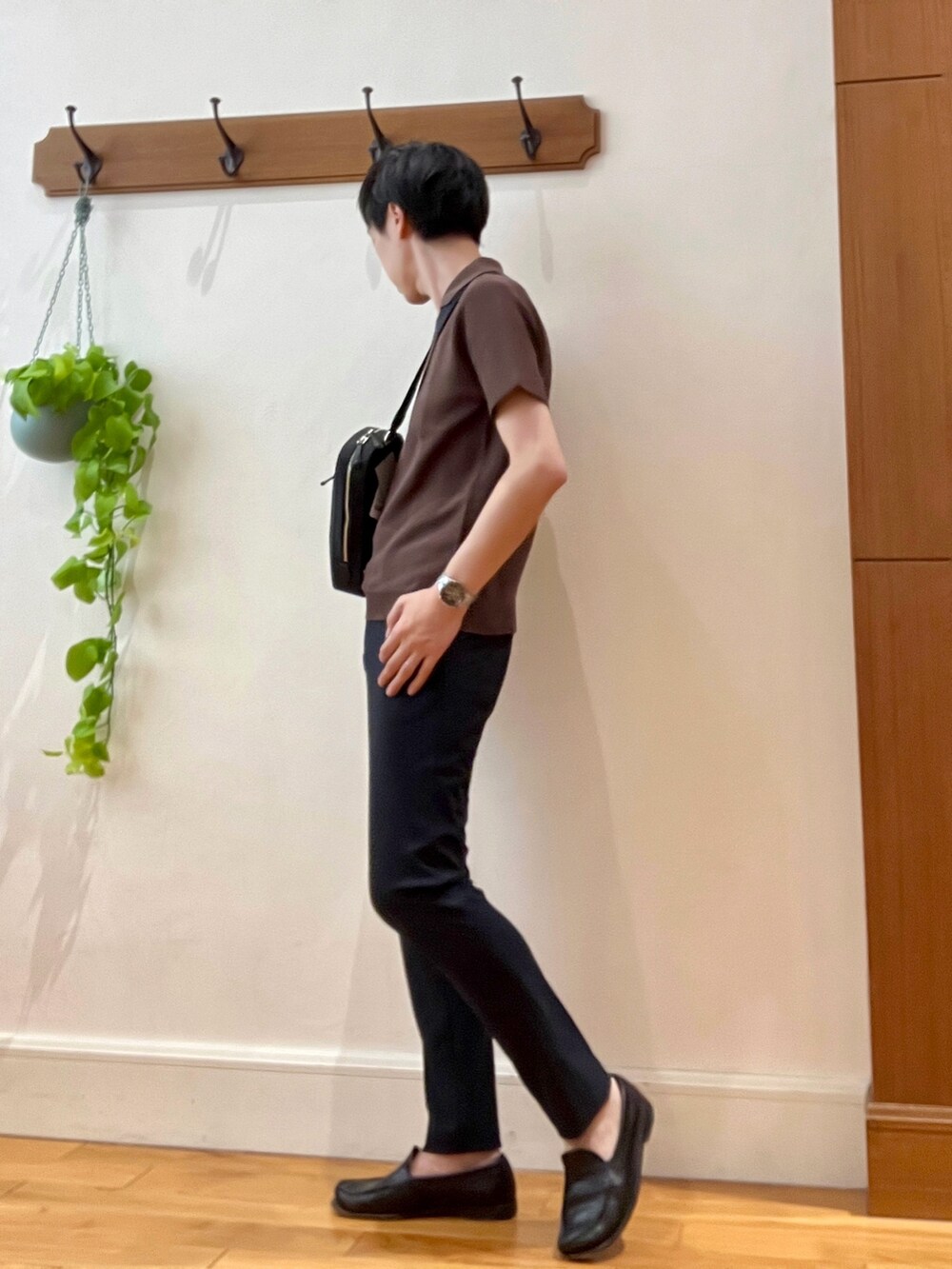 ブラウン系のポロシャツ、ブルー系のその他パンツ、ブラック系のボディバッグ/ウエストポーチを着用したメンズの春コーディネートの2枚目の写真