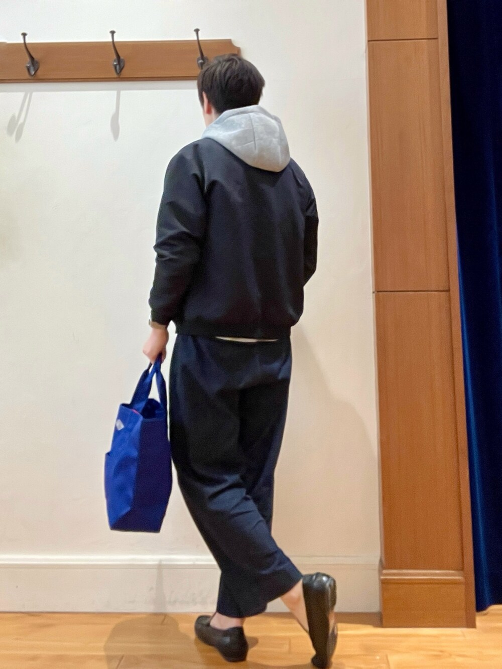 ブラック系のブルゾン、グレー系のパーカー、ブルー系のデニムパンツを着用したメンズの春コーディネートの3枚目の写真