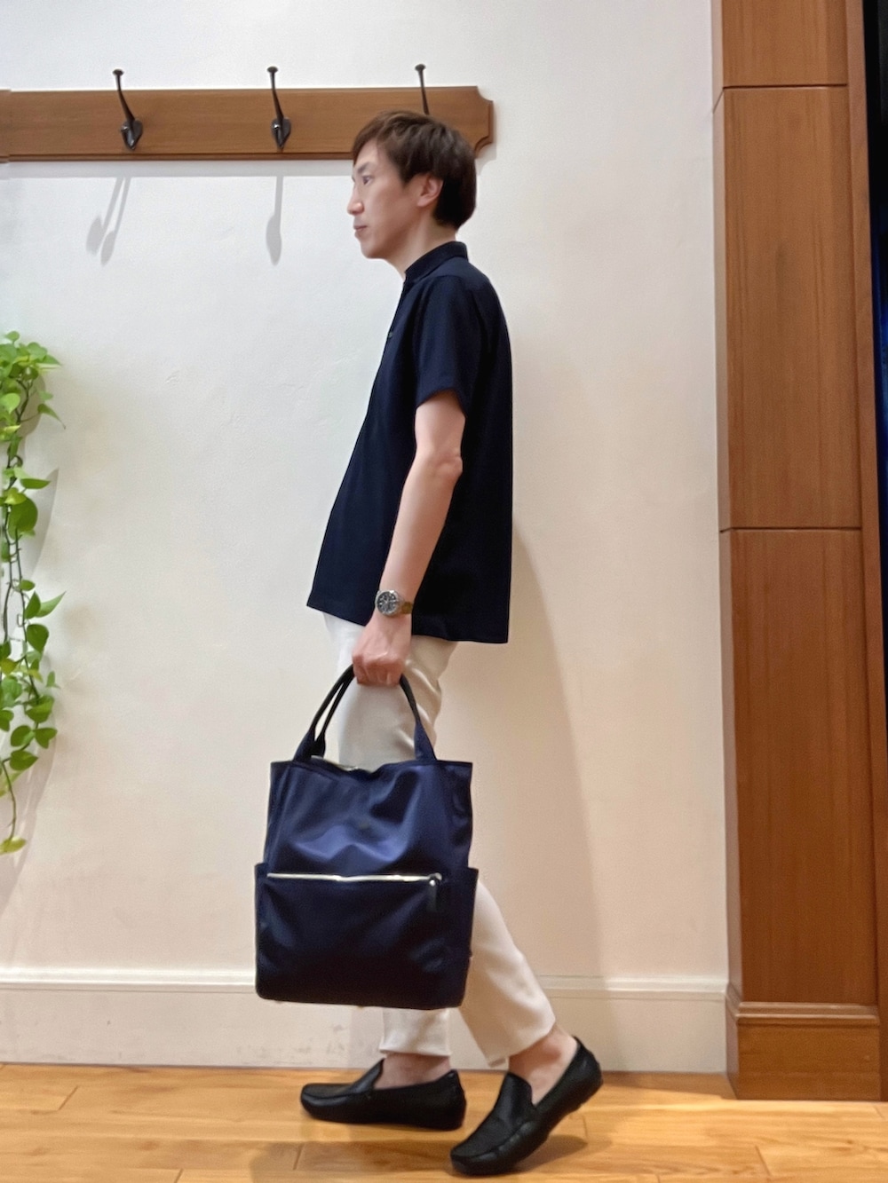 ブルー系のトートバッグ、ブルー系のポロシャツ、ホワイト系のその他パンツを着用したメンズの夏コーディネートの3枚目の写真