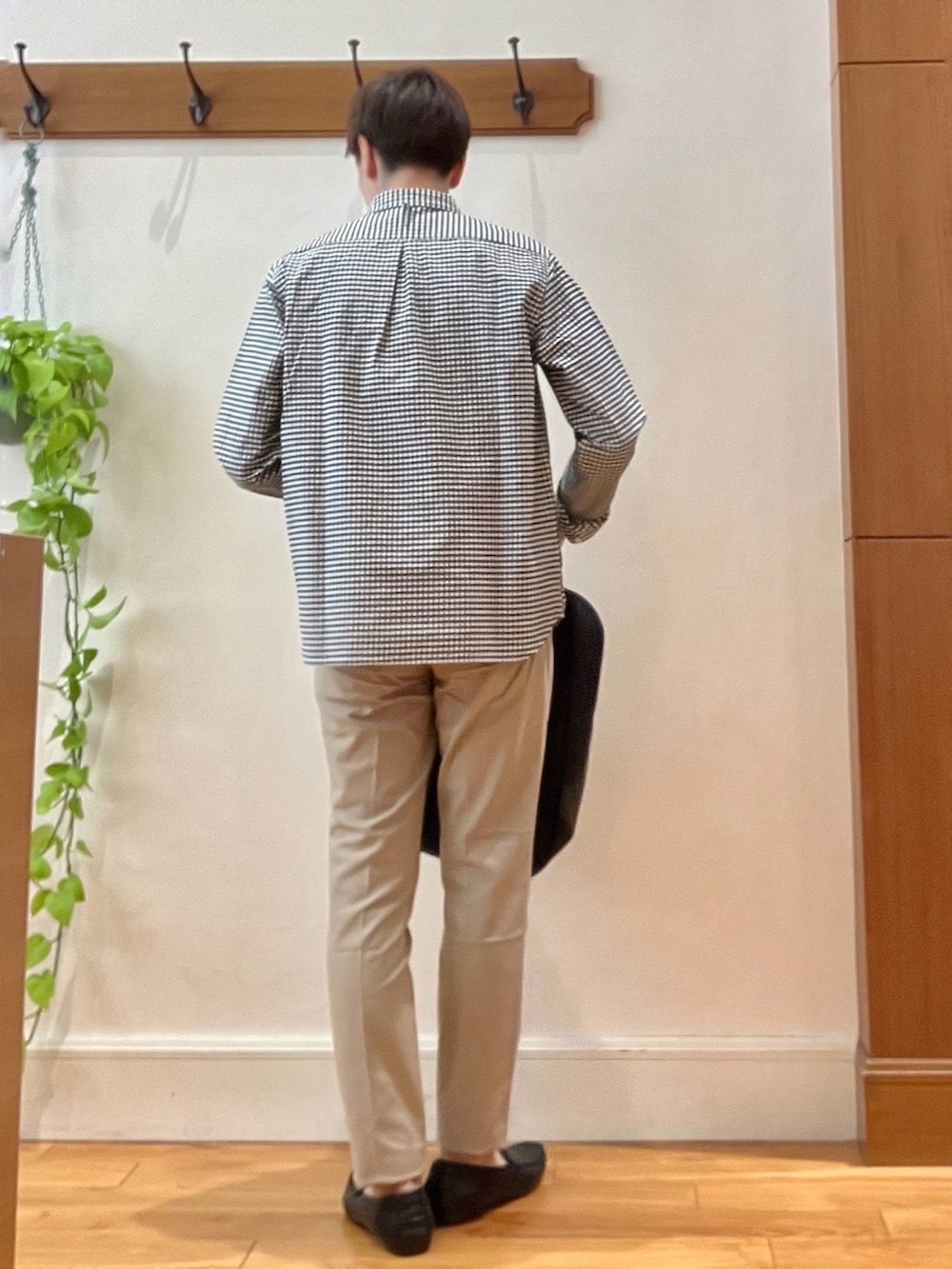ブラック系のシャツ/ブラウス、グレー系のバックパック/リュック、ベージュ系のチノパンツを着用したメンズの春コーディネートの4枚目の写真
