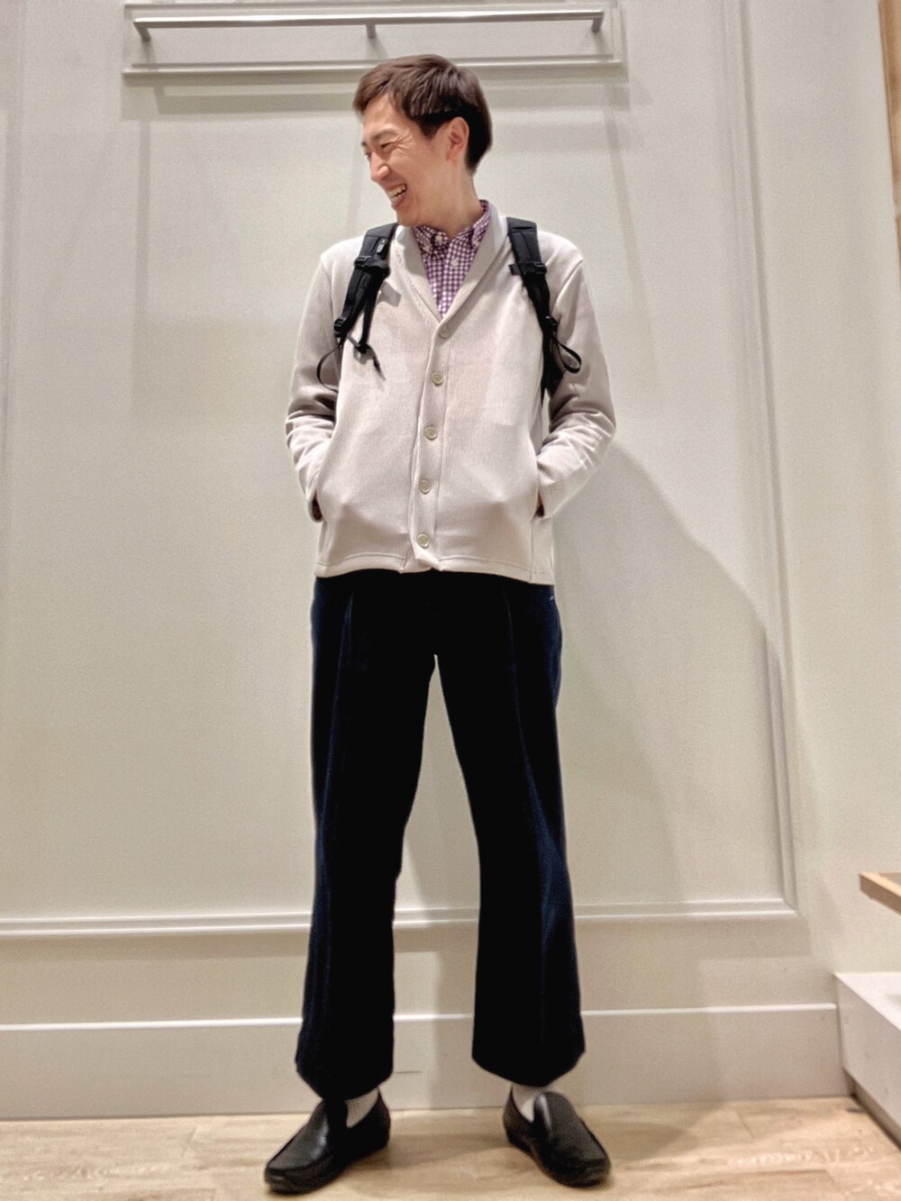 ベージュ系のカーディガン/ボレロ、ブラック系のバックパック/リュックを着用したメンズの冬コーディネートの2枚目の写真