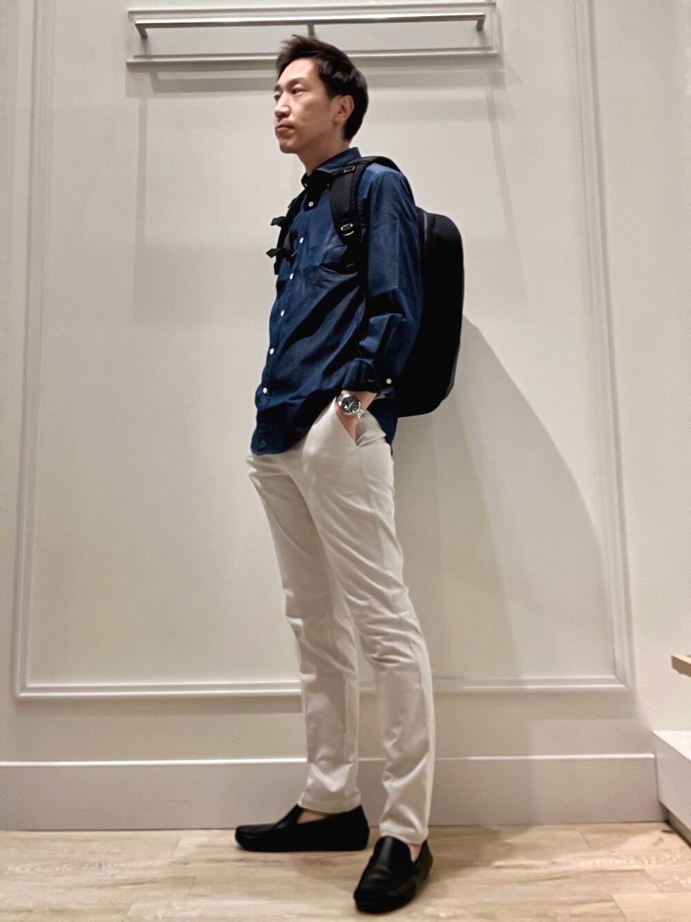 ブラック系のバックパック/リュック、グレー系のチノパンツ、ブルー系のシャツ/ブラウスを着用したメンズの冬コーディネートの3枚目の写真