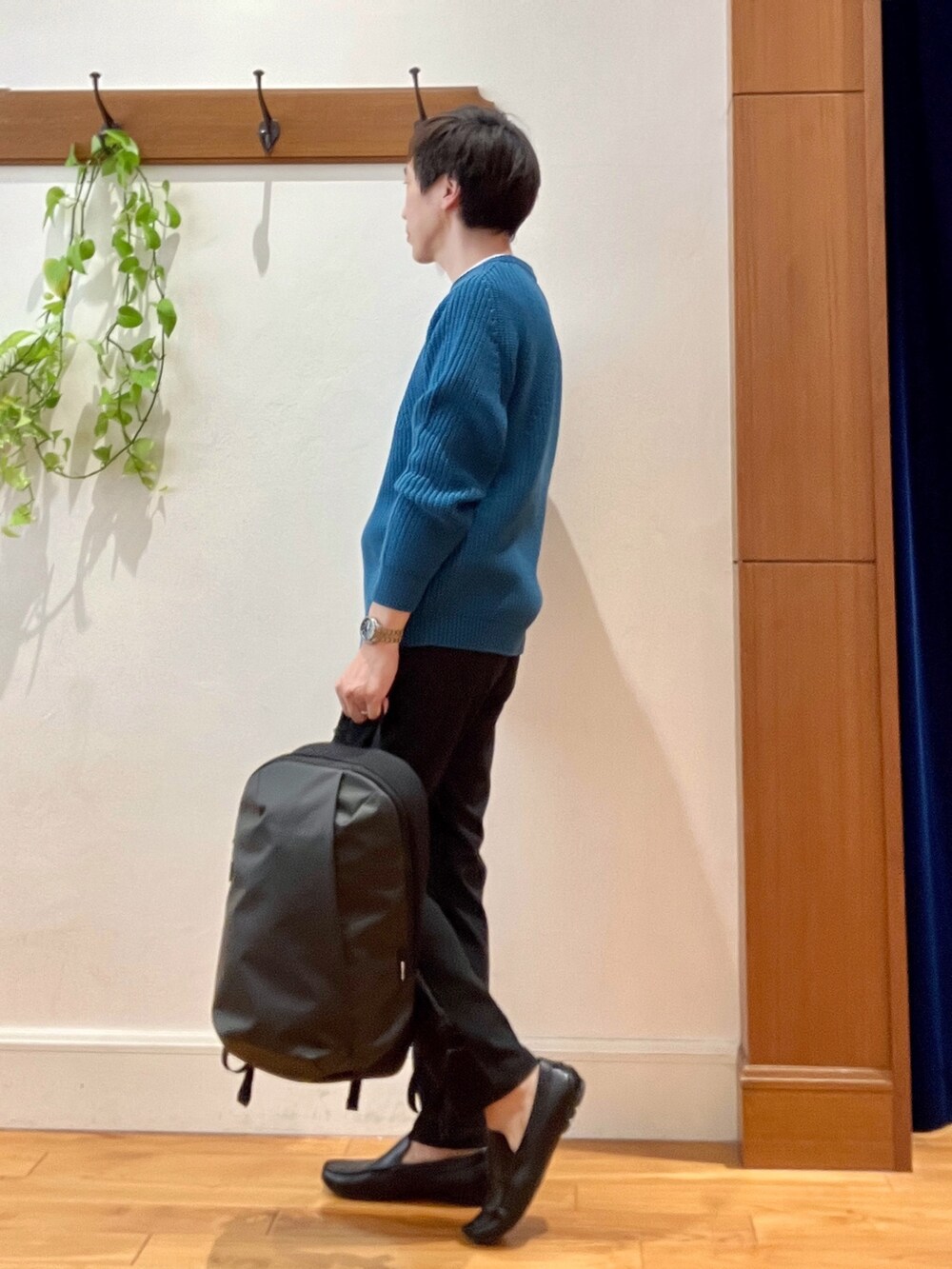 ブルー系のニット/セーター、グレー系のその他パンツ、グレー系のバックパック/リュックを着用したメンズの秋コーディネートの4枚目の写真