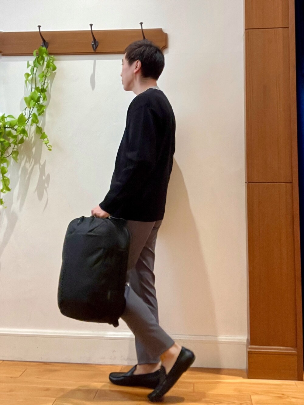 ブラック系のカーディガン/ボレロ、ホワイト系のTシャツ/カットソー、ブラック系のバックパック/リュックを着用したメンズの冬コーディネートの3枚目の写真