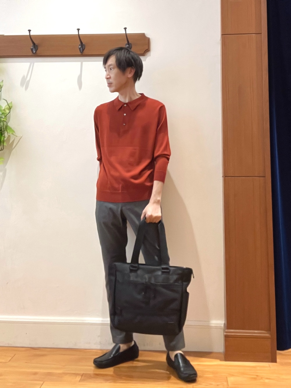 グレー系のその他パンツ、レッド系のニット/セーター、ブラック系のトートバッグを着用したメンズの秋コーディネートの7枚目の写真