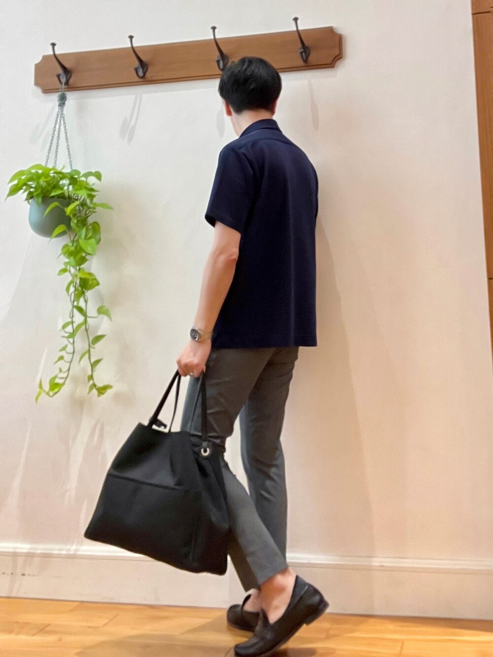 グレー系のその他パンツ、ブルー系のポロシャツ、ブラック系のトートバッグを着用したメンズの春コーディネートの3枚目の写真