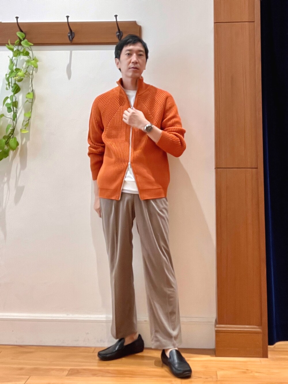 オレンジ系のニット/セーター、ブラック系のバックパック/リュック、ホワイト系のTシャツ/カットソーを着用したメンズの秋コーディネートの2枚目の写真