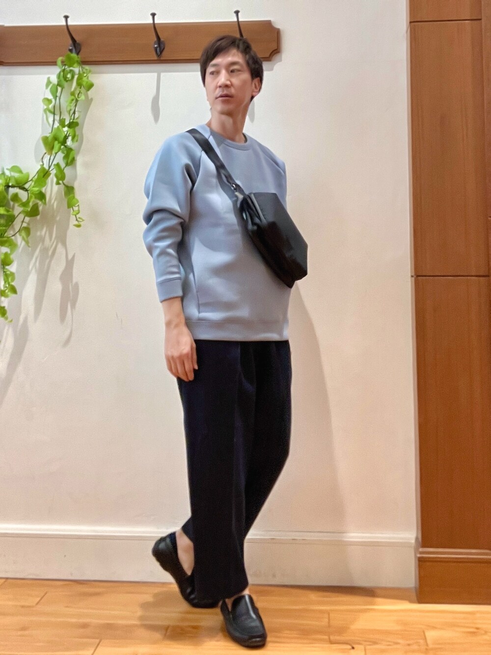 ブルー系のデニムパンツ、ブルー系のスウェット、ブラック系のショルダーバッグを着用したメンズの冬コーディネートの6枚目の写真