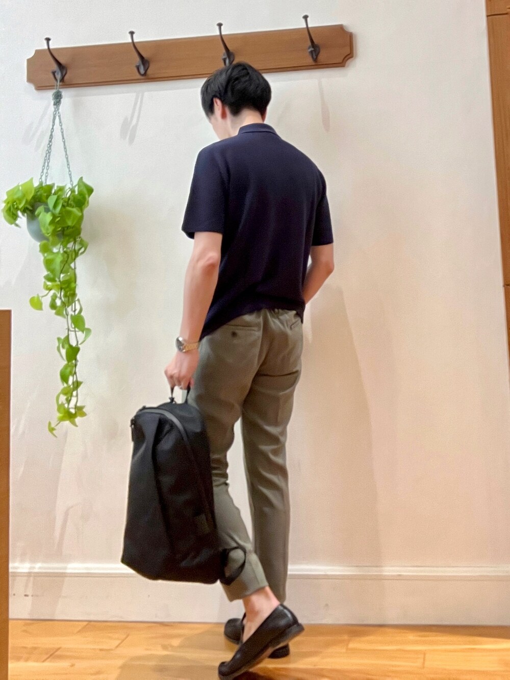 ブルー系のポロシャツ、ブラック系のバックパック/リュック、ブラック系のその他パンツを着用したメンズの春コーディネートの5枚目の写真