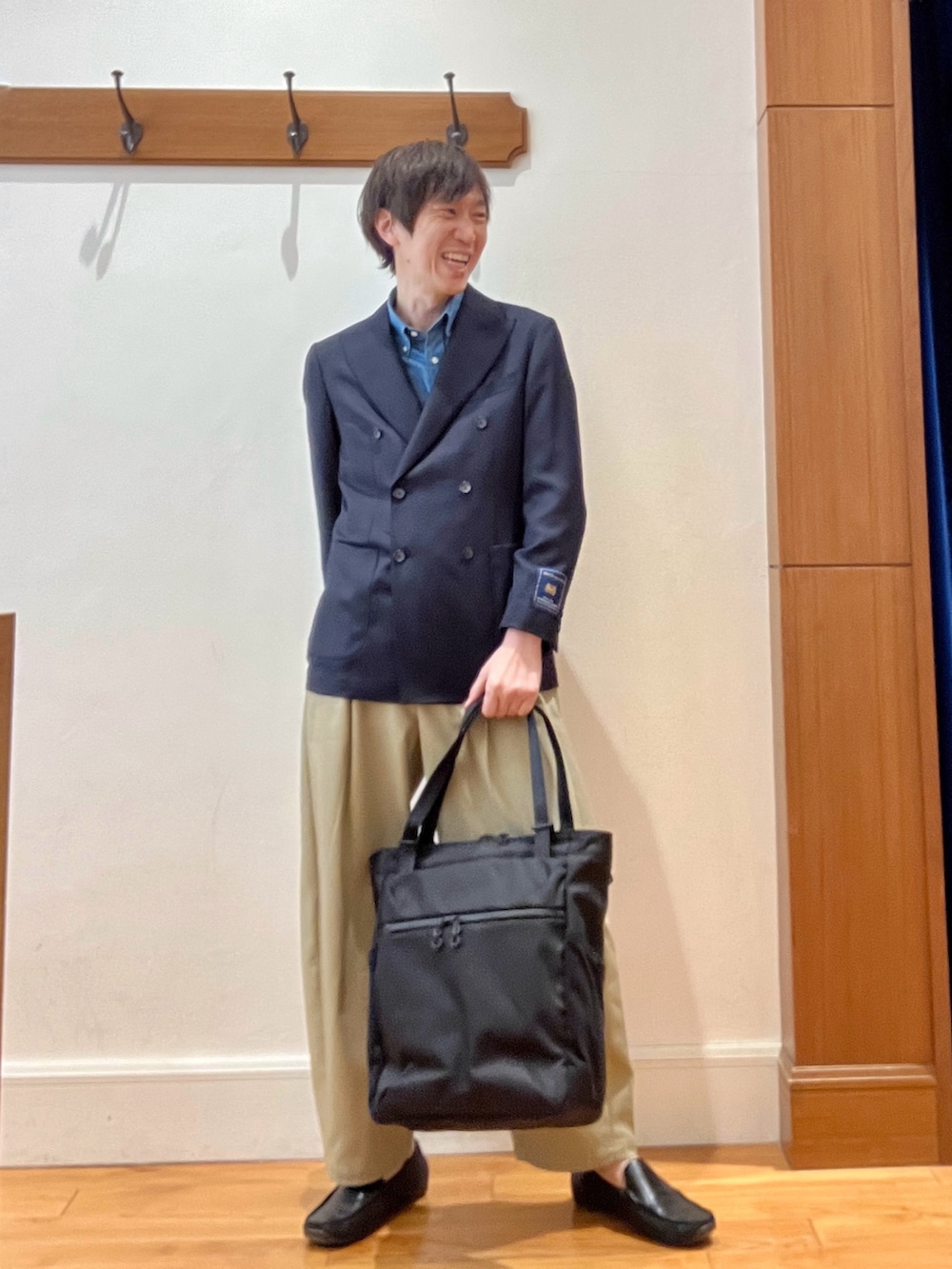 ブルー系のテーラードジャケット、ブラック系のトートバッグを着用したメンズの春コーディネートの2枚目の写真